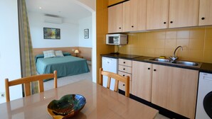 A compact kitchen with wooden cabinets, a built-in dishwasher, and a countertop sink.