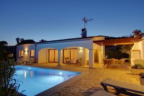 Ein Poolbereich mit Pool, Liegestühlen und einer Pergola.