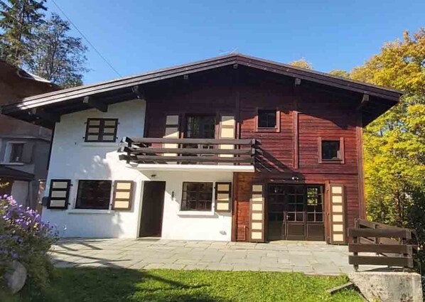 A two-story house with a balcony, a front door, and a small porch area. - Mountain Chalet, in the heart of Les Houches and the Chamonix Mont Blanc Valley (Les Houches)
