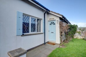 A house with a light blue door, a window with blue shutters, and a nameplate reading "SNECASTLE".