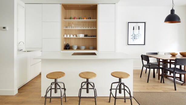 A modern kitchen with white cabinetry, a wooden countertop, and three stools. - Miramon by FeelFree Rentals (San Sebastián)