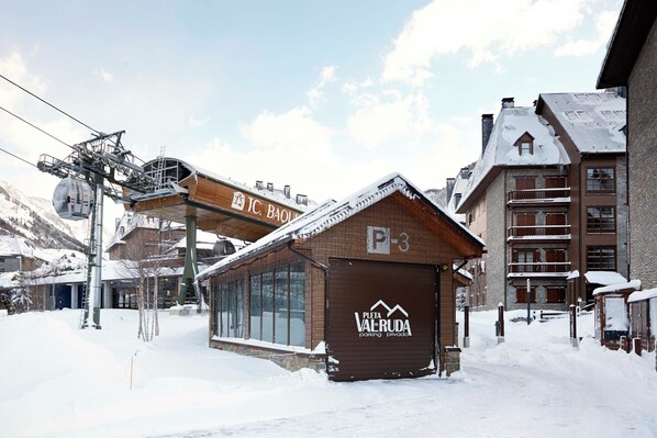 A snow-covered building with a sign for "P-3" and "Valruda" indicating a private parking area. - Val de Ruda Luxe 49 by FeelFree Rentals (Baqueira)