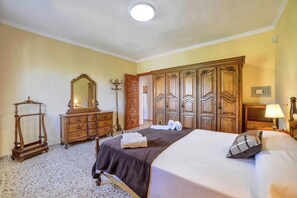 A hotel room with a bed, a dresser, a mirror, and a wardrobe.
