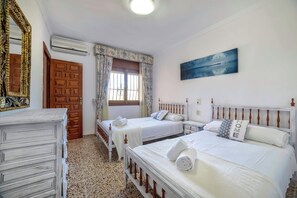 A hotel room with two beds, a large mirror, a painting, and a wooden door. - Villa Puchero - PlusHolidays (Calpe)