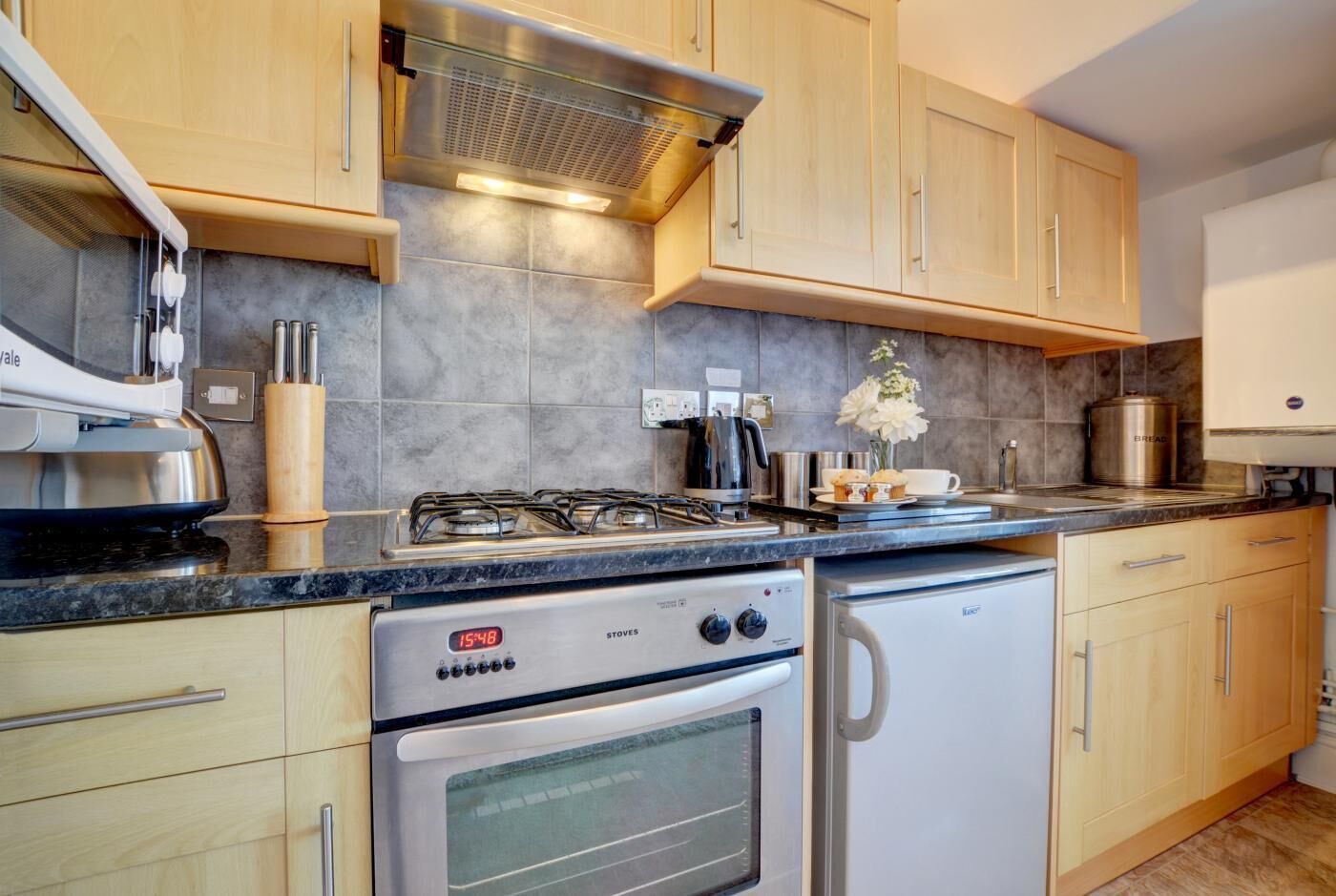 Una cocina moderna con estufa a gas, horno y cafetera.