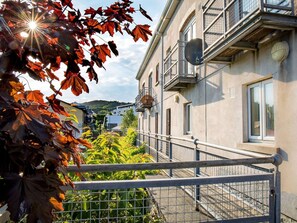 A residential building with a balcony, a gate, and a view of the surrounding area.