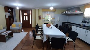 Um espaço compacto com sofá, mesa de jantar, cadeiras e cozinha compacta.