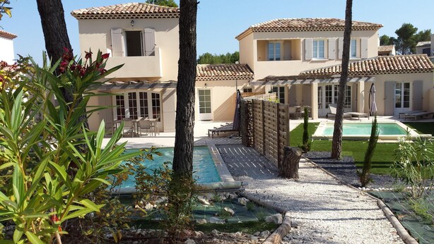 A Mediterranean-style villa with a swimming pool, outdoor seating, and a well-maintained garden.