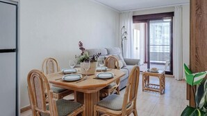 A dining area with a wooden table set for four, surrounded by wicker chairs. - Nautilus 39B - Grupo Turis - Calpe, Costa Blanca (Calpe)