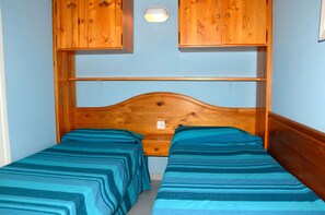 Tabla de planchar con plancha y ropa de cama