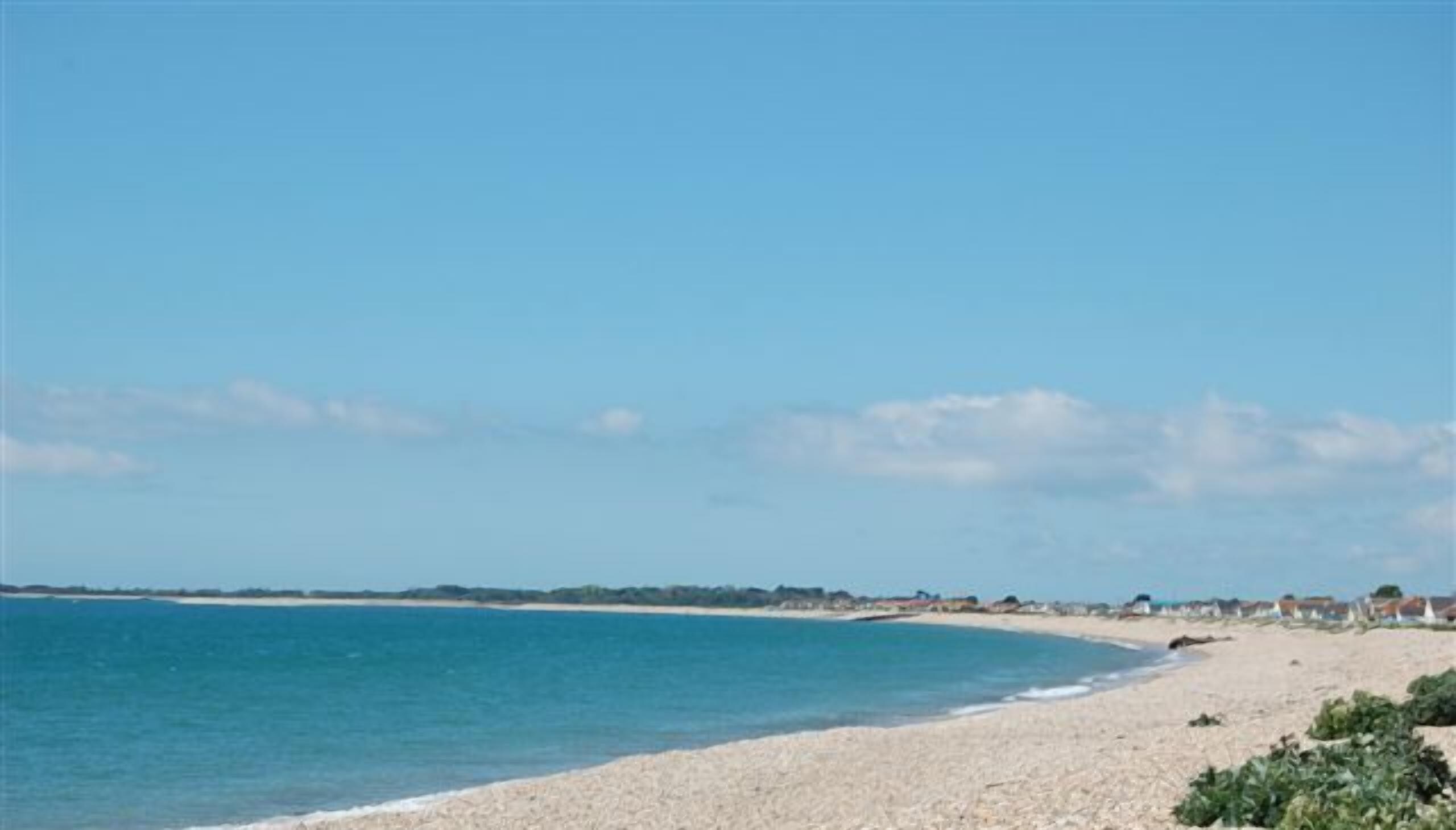 Une plage de galets, sous un ciel bleu et dégagé.