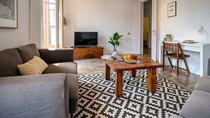 Una sala de estar moderna con un sofá, una mesa de centro y un televisor.