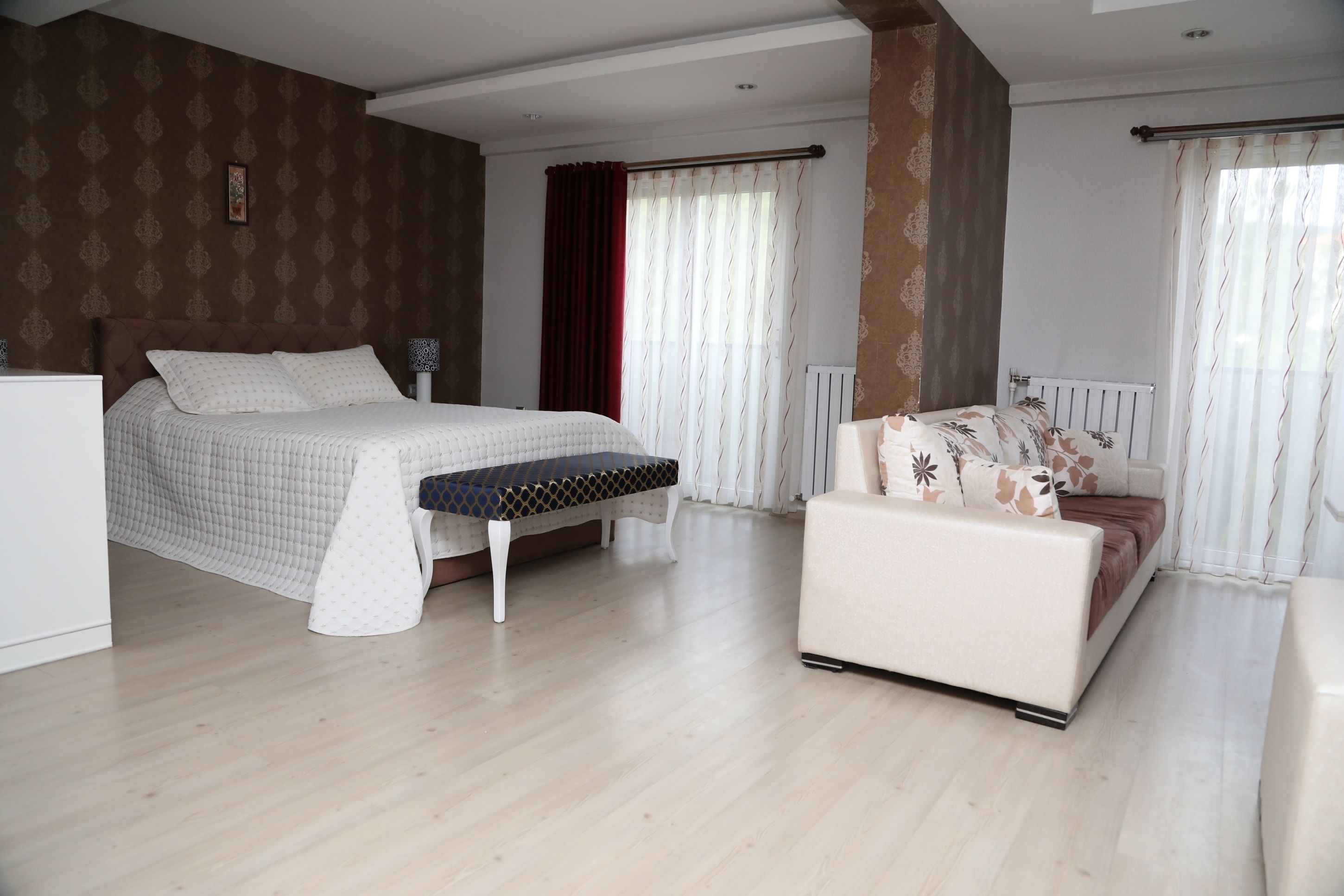 Une chambre à coucher avec un lit, un banc, un canapé et un radiateur.