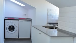 Cuina petita amb rentadora, un rentaplat i una superfície de treball.