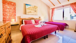 Una habitación con cama, cómoda, cuadro y ventana con cortinas.