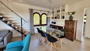 A modern living space with a staircase, dining area, and kitchen. - Villa Castell - Urb Mas Pere (Calonge)