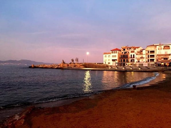 Un hôtel situé sur la côte, composé de plusieurs bâtiments, avec une plage de sable et une mer calme.