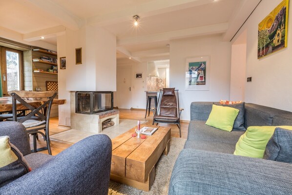 A living room with a fireplace, a sofa, a coffee table, and a bookshelf.
