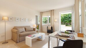 A modern living room with a sofa, coffee table, and dining area. - GUESTHOUSE PALMA - ADULTS ONLY (Palma de Mallorca)