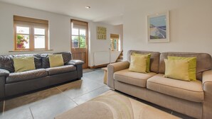 A living room with two sofas, a rug, and a framed picture on the wall.