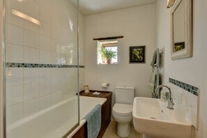 A bathroom with a bathtub, toilet, sink, and a small window with a plant. - The Ballroom, near Wheddon Cross (Wheddon Cross)