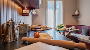 Een moderne keuken met een houten aanrecht, een deegroller, een koffiepot en een snijplank.