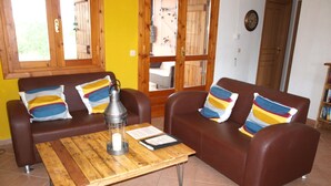 A living room with two brown leather sofas, a wooden coffee table, and a metal lantern.