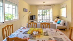 A dining area with a table set for four, a television, and a sofa in the background. - Villa Borras w/ private pool, 3km to beach! (El Vendrell)