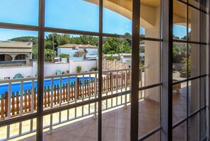 Enjoy a poolside view from this balcony with a view of the surrounding buildings.