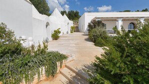 A pathway leading to a building with white walls and a covered porch. - Casa Murredda by Perle di Puglia (Ostuni)