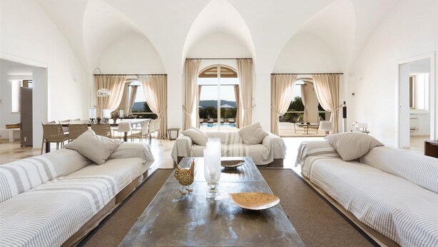 A spacious living area with a central coffee table, two sofas, and a dining table with chairs. - Casa Murredda by Perle di Puglia (Ostuni)