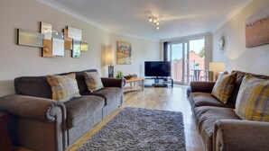 A living room with two sofas, a TV, and a coffee table. - 2 Bed in Woolacombe (oc-narr9) (Woolacombe)