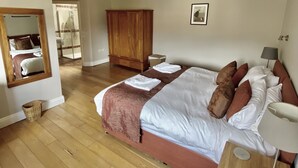 Ein Schlafzimmer mit einem großen Bett, einem Holzschrank und einem Spiegel.