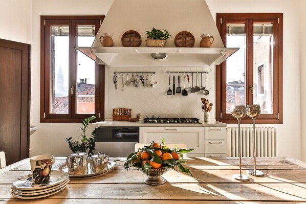 A kitchen with a central island, white cabinets, and a window with a view of buildings.