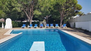 Une piscine rectangulaire à l’eau d’un bleu limpide, entourée d’une terrasse carrelée.