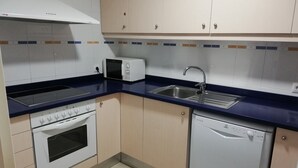 A kitchen with a microwave, sink, stove, oven, and dishwasher. - MESTRAL 1-6 (L'Escala)