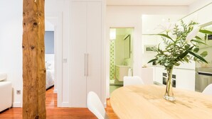 Un salon moderne avec un plancher en bois, des meubles blancs et un coin repas comprenant une table et des chaises.