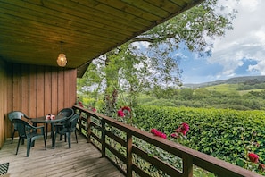 Enjoy a serene outdoor space with a table and chairs overlooking a lush landscape.