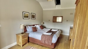 Ein Schlafzimmer mit Bett, Nachttischen, Teppich und Kleiderschrank.