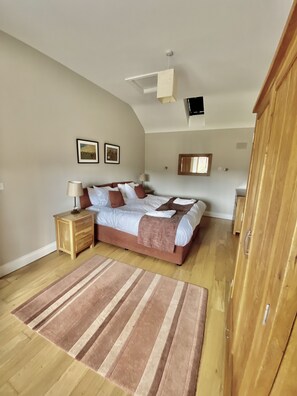 Une chambre à coucher avec un lit, des tables de chevet, un tapis et une armoire.