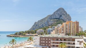 A coastal hotel with multiple floors, a beach in the foreground, and a prominent rocky mountain in the background. - Zafiro 35B - Grupo Turis - Calpe, Costa Blanca (Calpe)