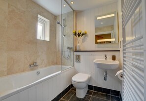 A modern bathroom with a freestanding bathtub, a toilet, and a sink.