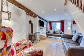A cozy living room with a fireplace, a sofa, a TV, and a staircase. - 3 Bed in Croyde (oc-yellow) (Croyde)