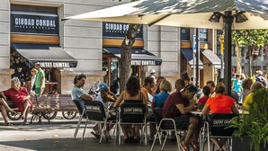 Outdoor seating at a restaurant with a sign reading "CIUDAD CONDAL CERVEZA". - Pedrera - Habitat Apartments (Barcelona)
