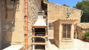 An outdoor stone building with a brick oven, a small window with shutters, and a potted plant. - Magnificent Memory Making - only 2km beach! (Palma de Mallorca)