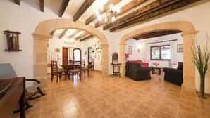 A spacious living area with a dining table, chairs, and a sofa. There are wooden beams on the ceiling and a chandelier. - Magnificent Memory Making - only 2km beach! (Palma de Mallorca)