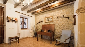 A rustic interior with a stone wall, wooden furniture, and a chandelier. - Magnificent Memory Making - only 2km beach! (Palma de Mallorca)