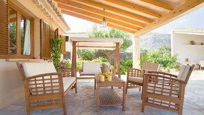 A covered outdoor seating area with wooden furniture and a pergola. - Pollensa retreat, walk to Old Town and 6km to beach! (Palma de Mallorca)