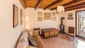 A cozy living room with a wooden ceiling, a sofa, a wooden cabinet, and framed pictures on the wall. - Little Vista, Smartno, Goriska Brda - 2 Bedroom Holiday House (Kojsko)