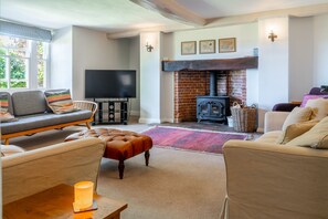 A cozy living room with a fireplace, comfortable seating, and a flat-screen TV.